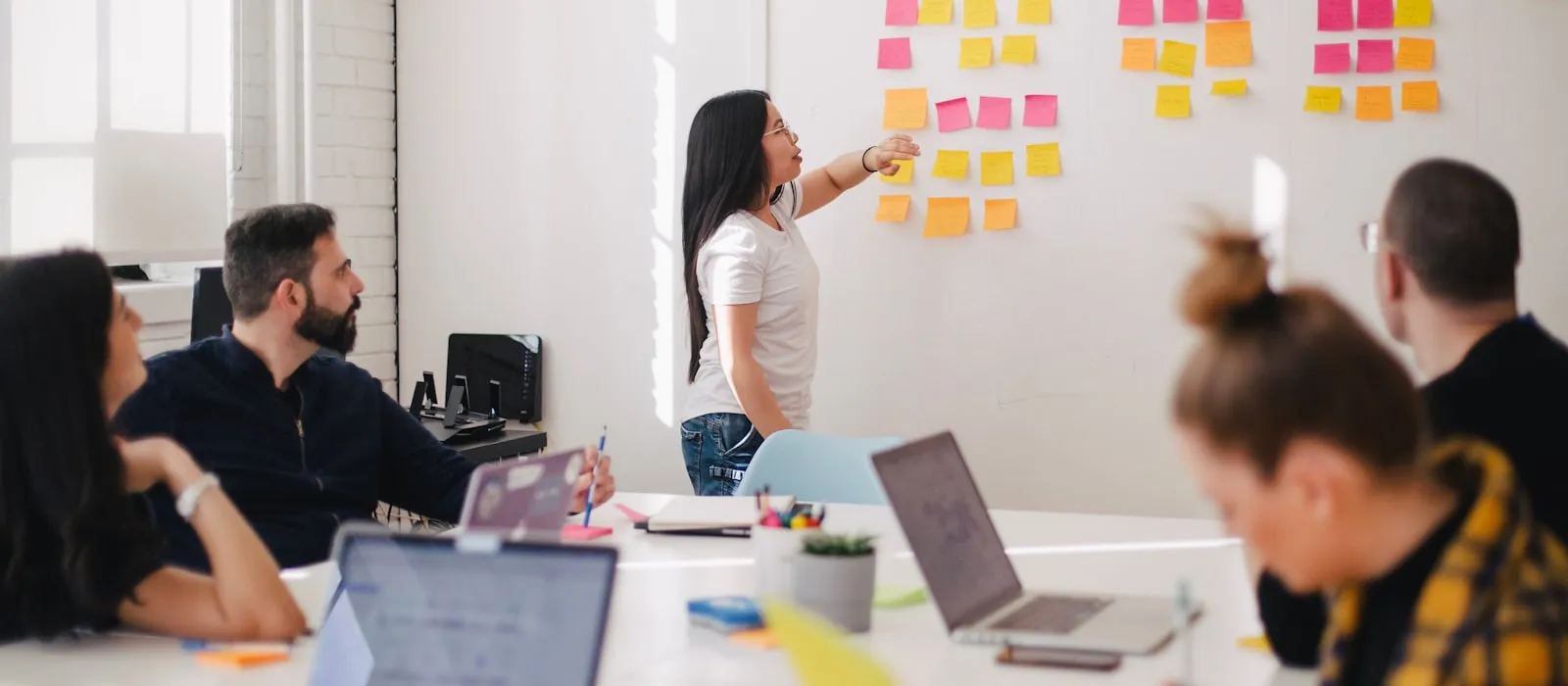 Marketing team planning a campaign around a wall of sticky notes