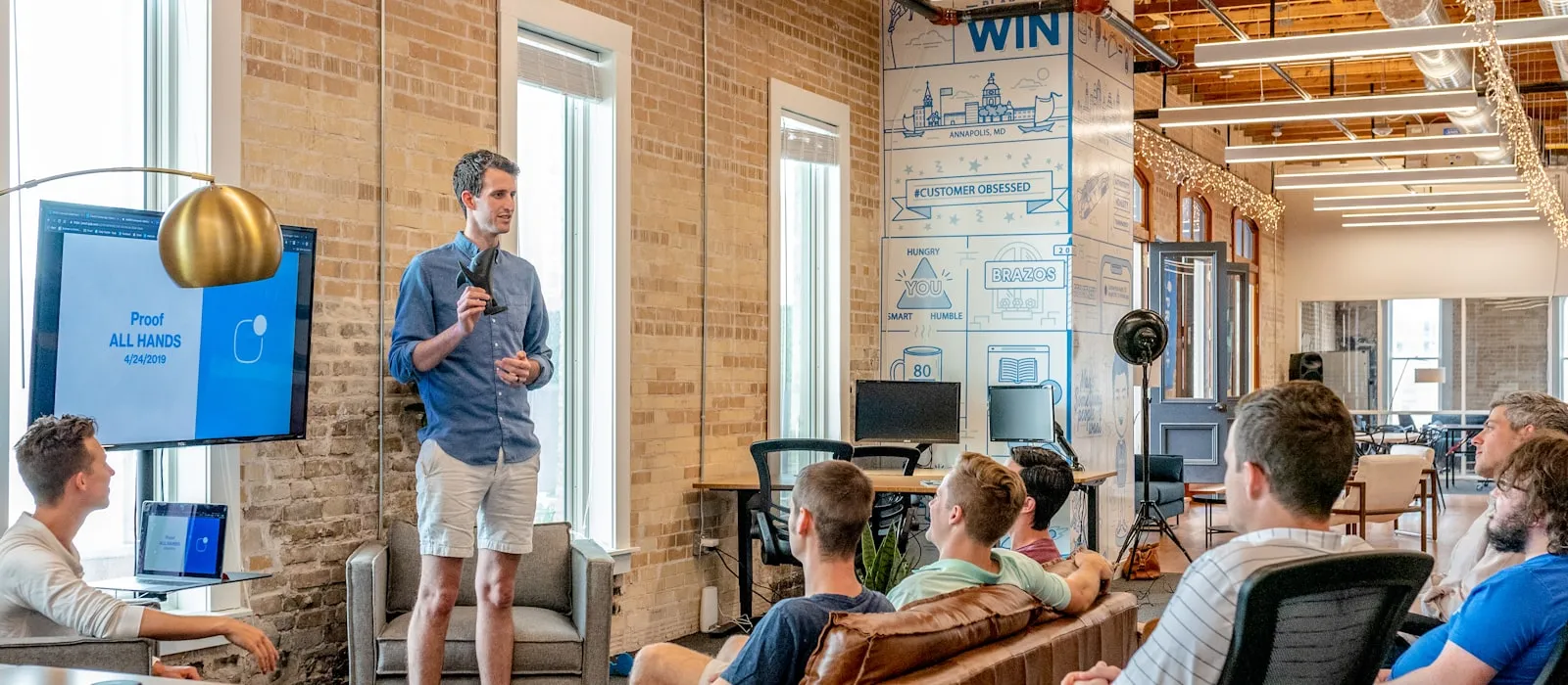Team gathered in an open office for an all-hands presentation